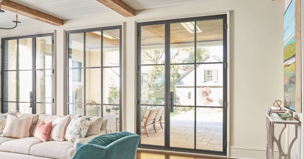 A modern iron door complete with large glass window panels.