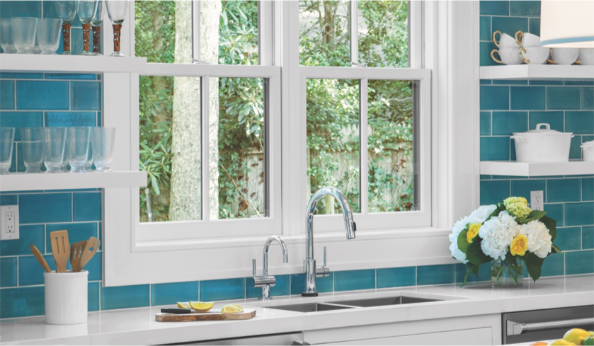 Kitchen sink with white custom windows behind.