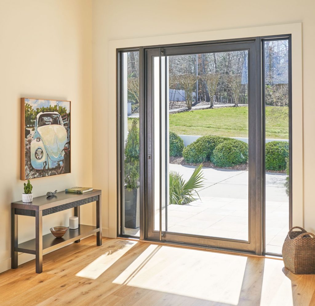 Contemporary pivot front door with sidelights.