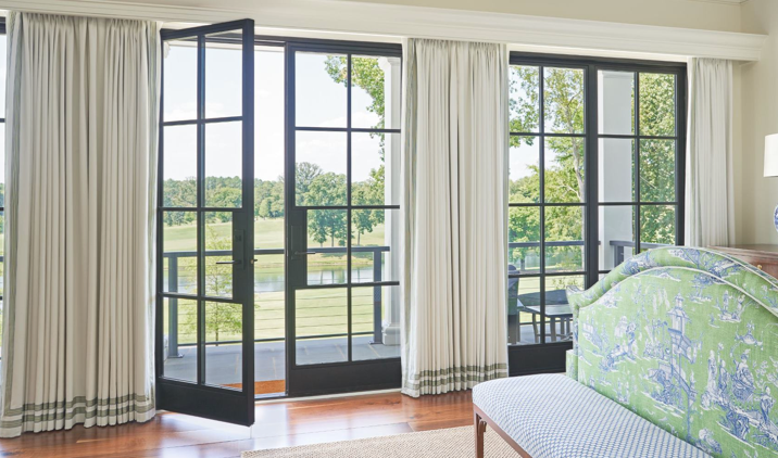 Modern door open to balcony looking out to golf course.