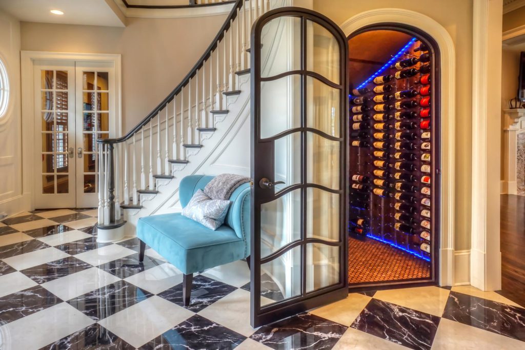 A custom wine cellar door in the foyer of a home.