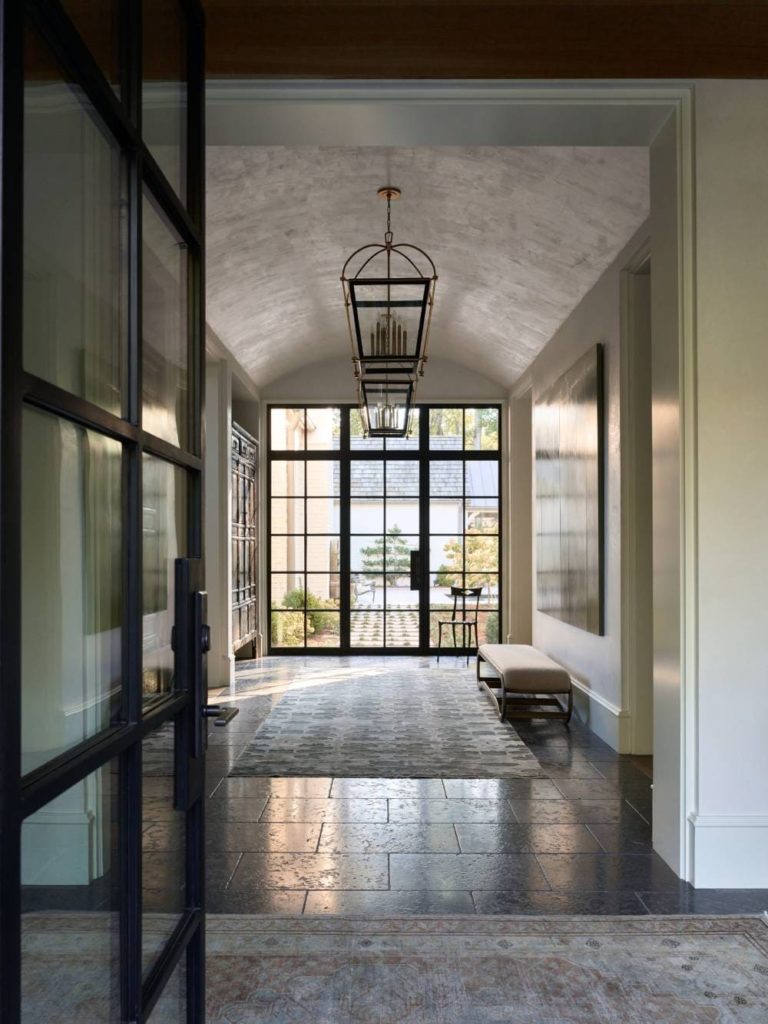 Modern glass doors seen from a dark hallway.