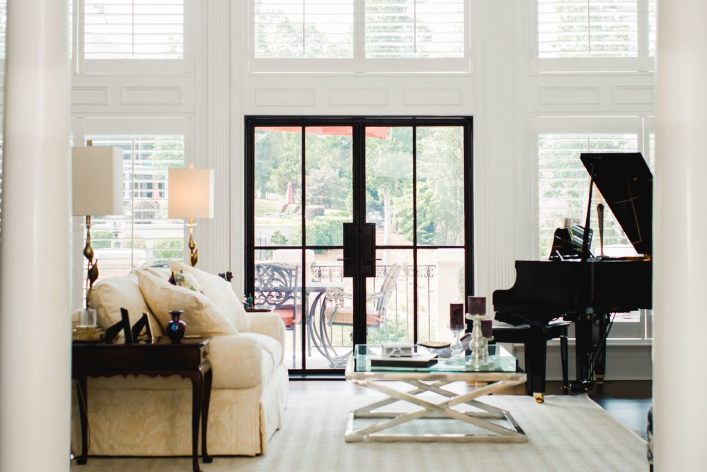 Modern patio door from the inside with a piano in the corner.