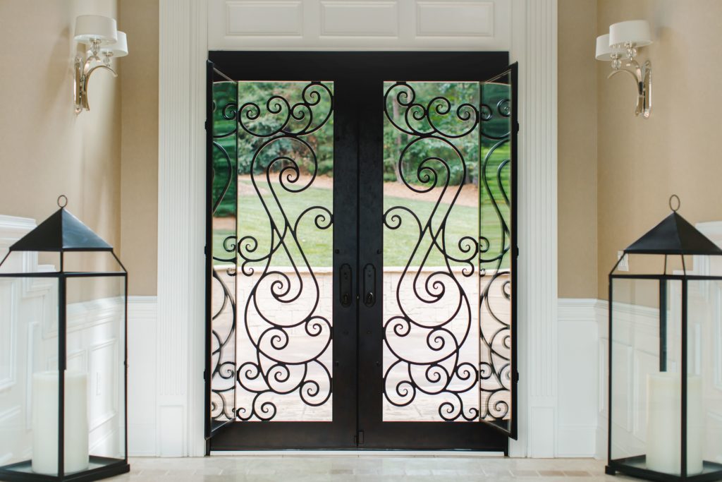 Ornate front doors seen from the inside with scrollwork.