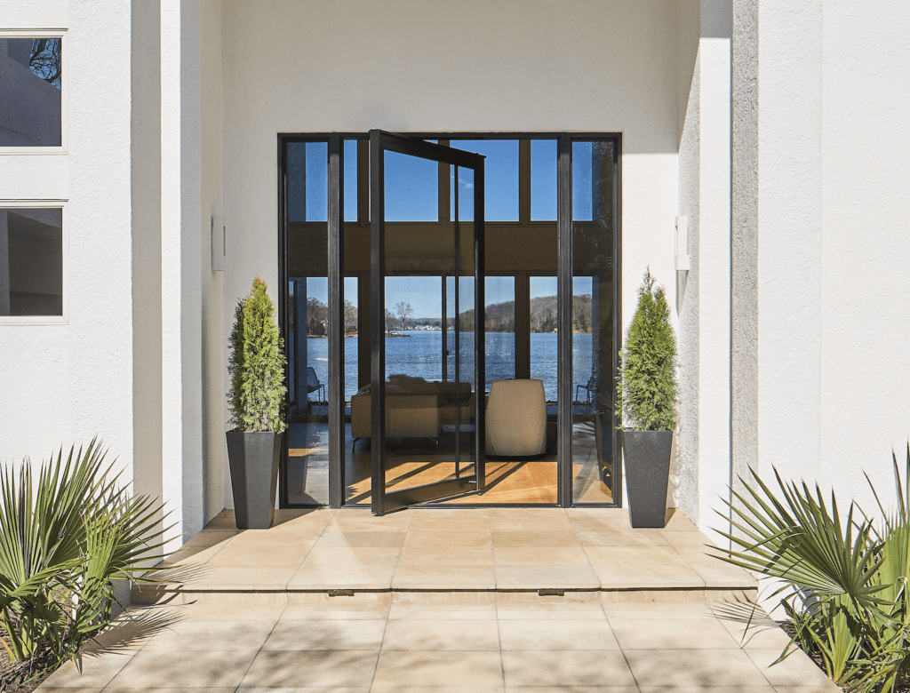Modern pivot door with view to a lake.
