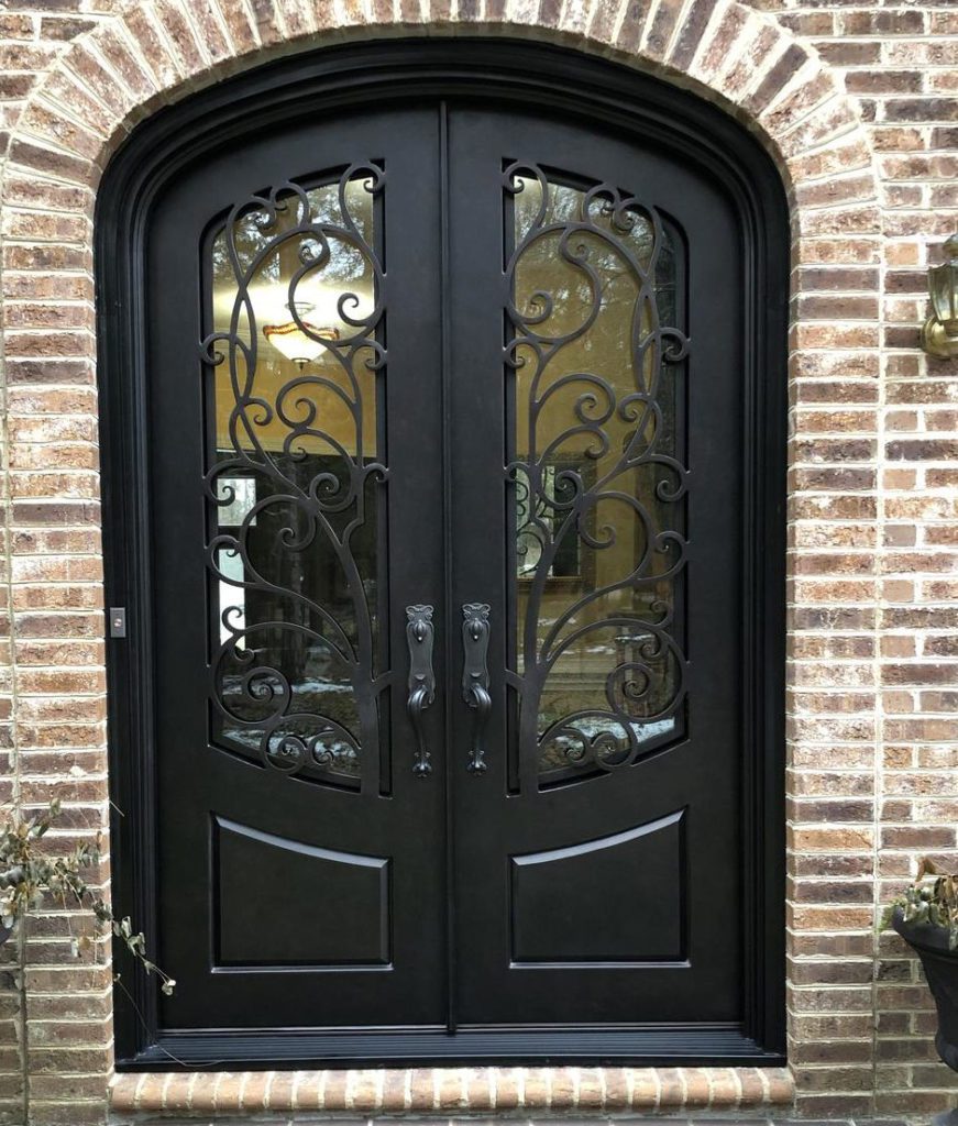 Arched ornate front door with clear glass.