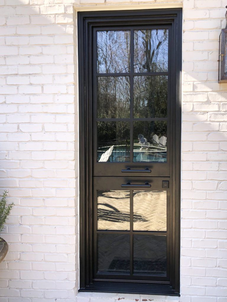 Slim single Dutch custom door with white brick exterior.