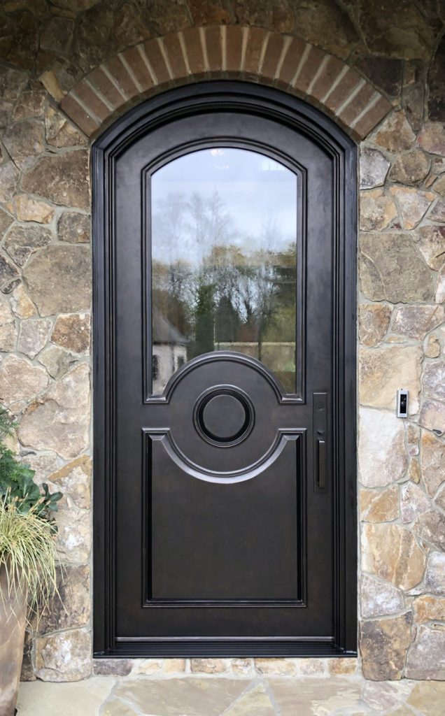 Traditional arched single door with stone exterior.