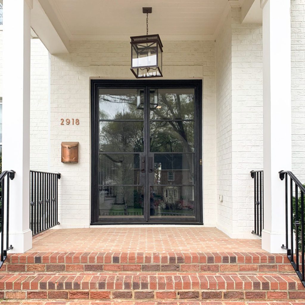 Modern front entryway with iron doors.