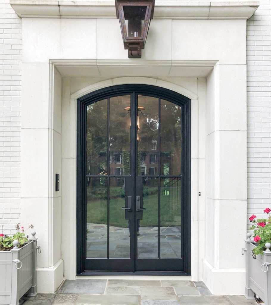 Arched double door entryway with white exterior.