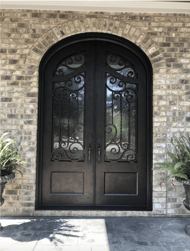 A double iron door featuring intricate scrollwork and a dark finish.