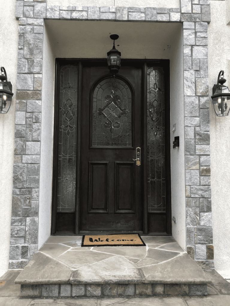A single panel wood door with two sidelights.