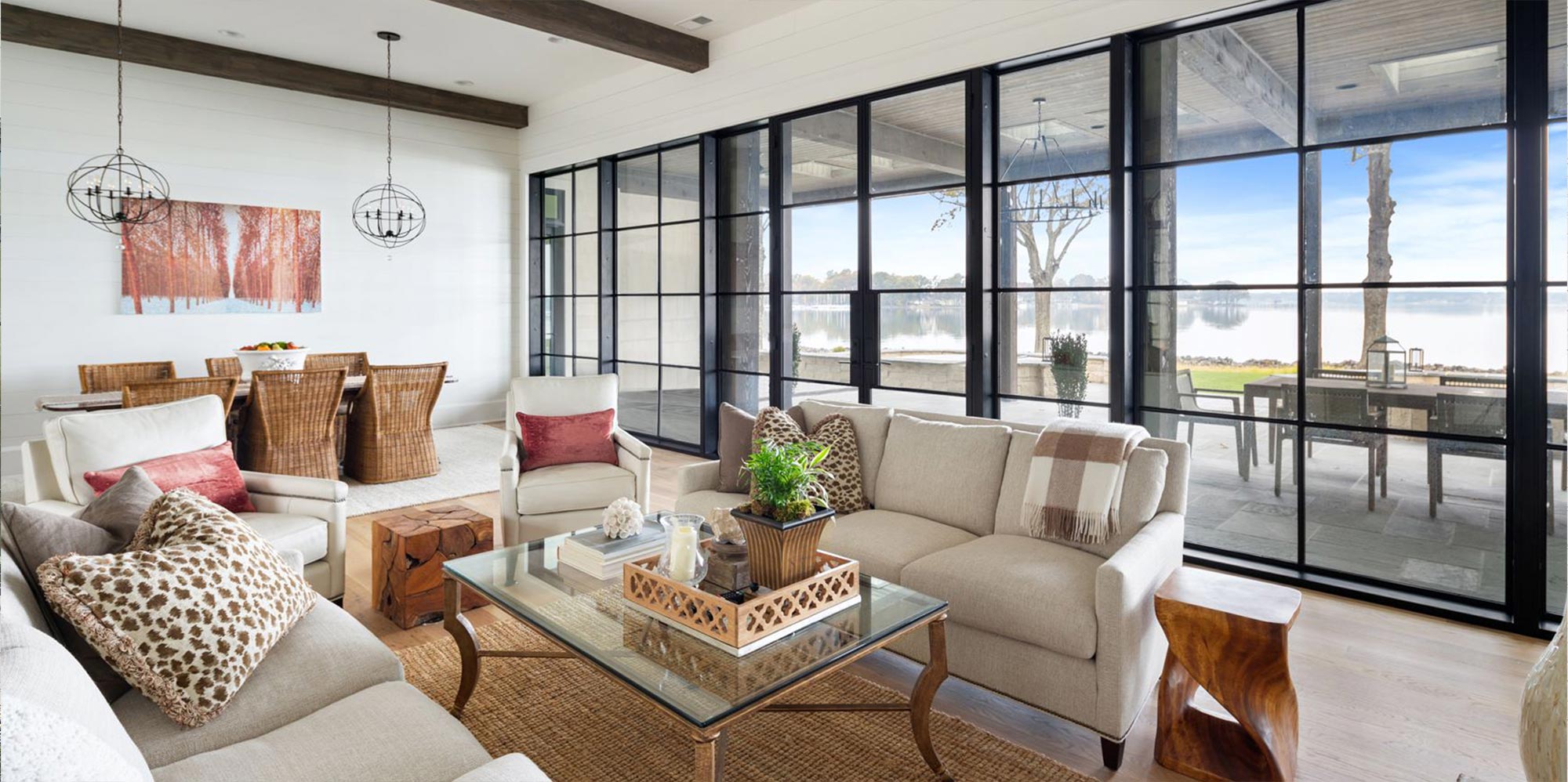 Living room and dining room with patio glass doors in back finish overlooking a lake